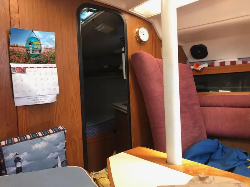 Slide: The Image of Interior of 1987 Hunter Legend 37 sailboat with cozy seating and calendar on wooden wall. - 18