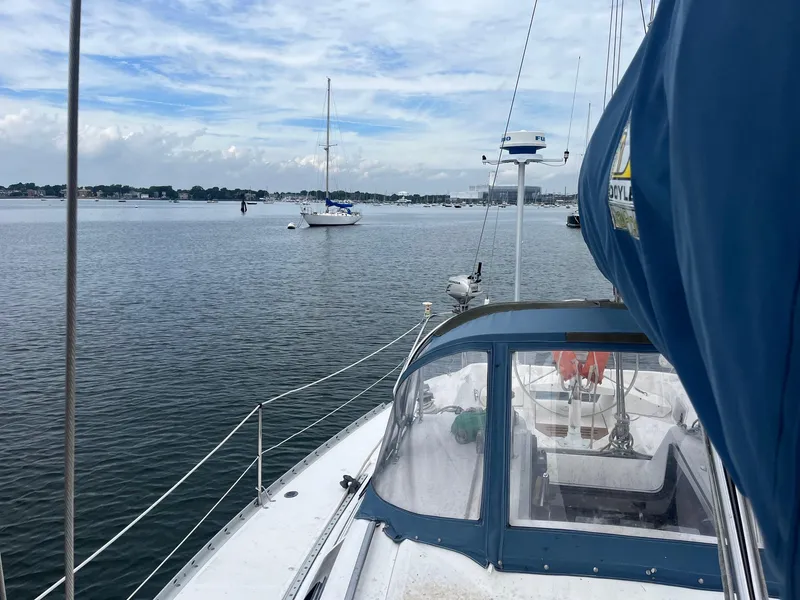 Slide: The Image of 1987 Hunter Legend 37 sailboat on calm waters with other boats in the background. - 6