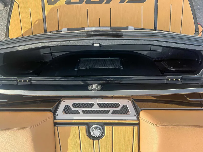 Slide: The Image of 2024 Supra SA boat storage compartment with sleek design and tan upholstery. - 23