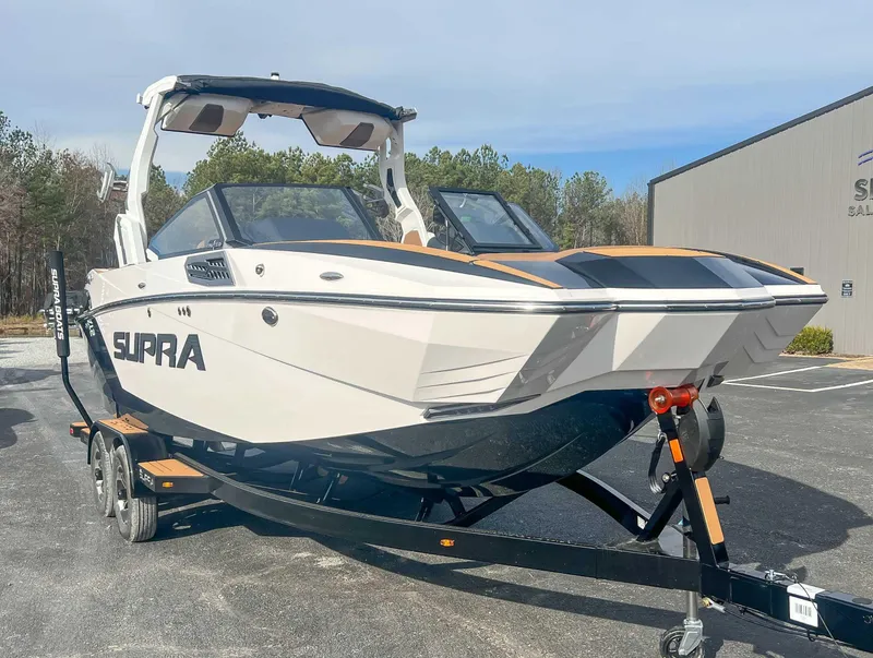 Slide: The Image of 2024 Supra SA boat on trailer, parked outdoors near a building. - 3