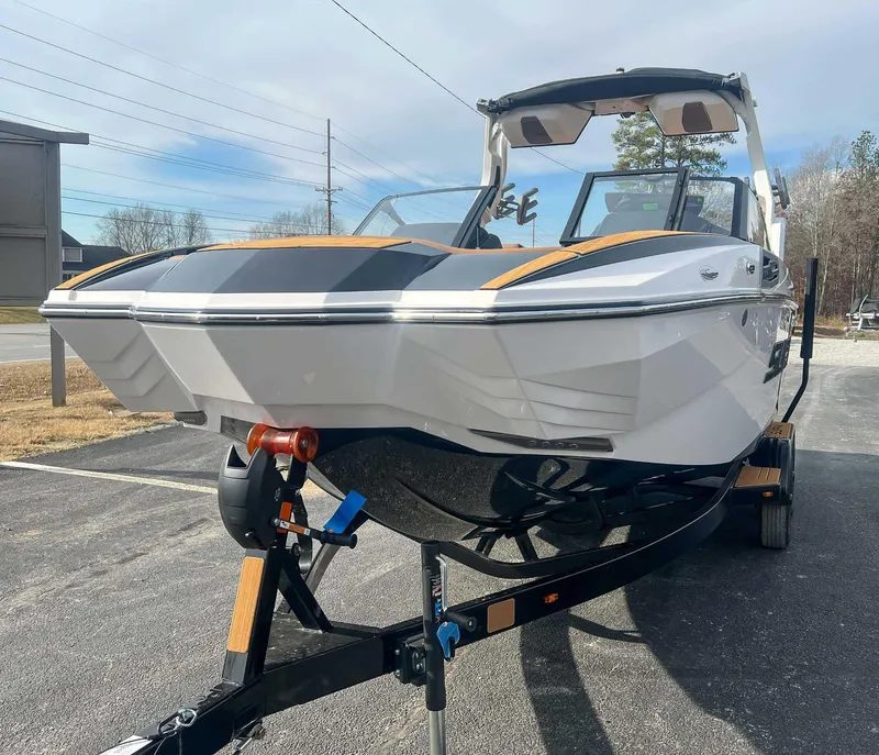 Slide: The Image of 2024 Supra SA boat on trailer, sleek design, parked outdoors. - 4