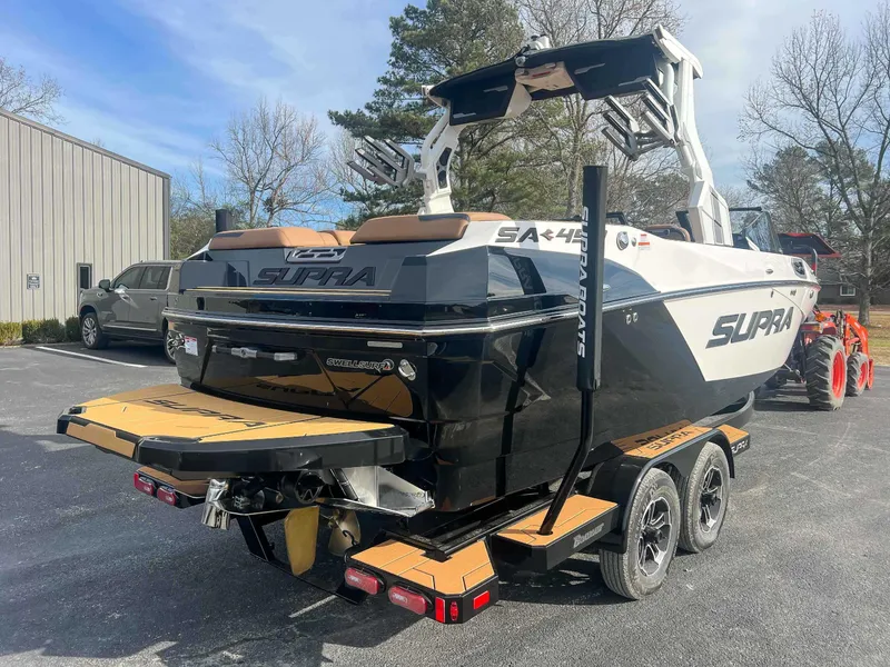 Slide: The Image of 2024 Supra SA boat on trailer, parked outdoors, showcasing sleek design and modern features. - 7