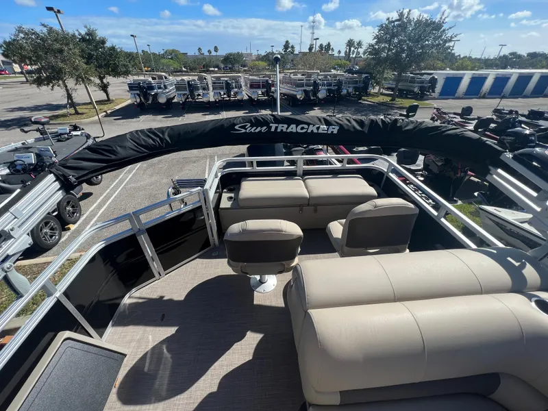 Slide: The Image of 2024 Sun Tracker SportFish 22 XP3 pontoon boat with cushioned seating. - 2