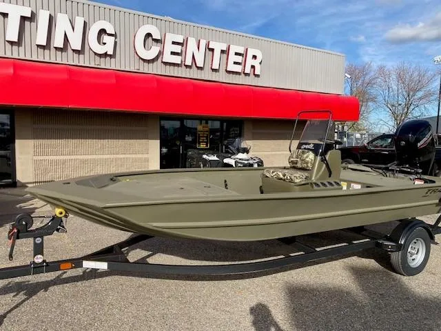 Slide: The Image of 2024 Tracker Grizzly 1860 CC boat on trailer outside a sporting center. - 2