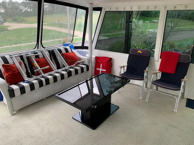 Slide: The Image of Enclosed deck area of a 1998 Viking 60 CMY yacht with seating and table. - 42