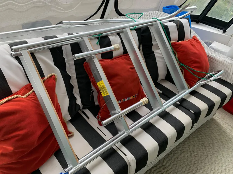 Slide: The Image of Metal ladder on striped boat seat with red cushions, Viking 60 CMY 1998. - 43