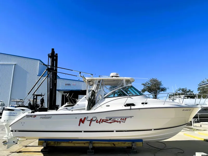 Slide: The Image of 2005 Pursuit 3070 Offshore boat on a trailer in a marina. - 1