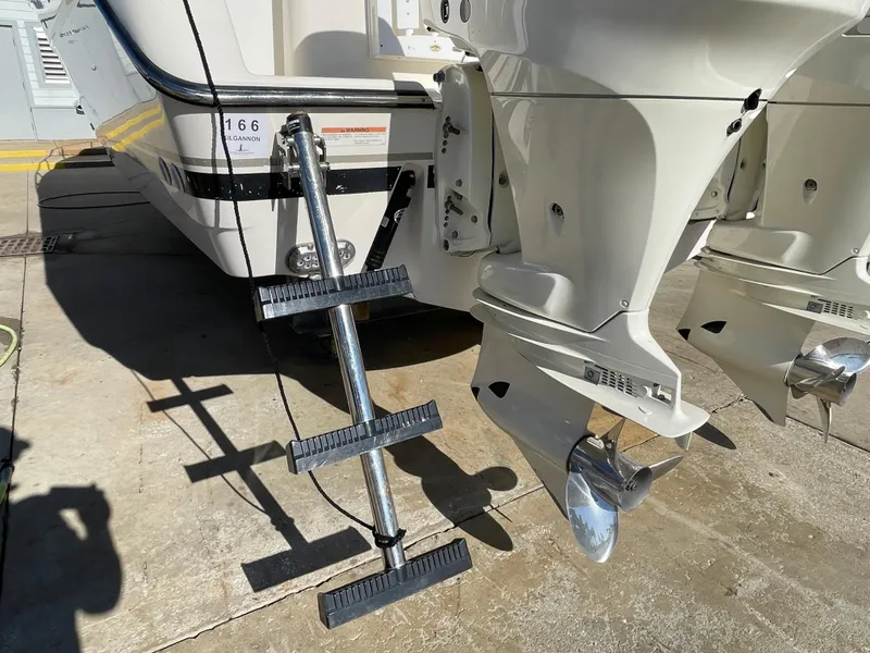 Slide: The Image of 2005 Pursuit 3070 Offshore boat with dual outboard motors and boarding ladder. - 14
