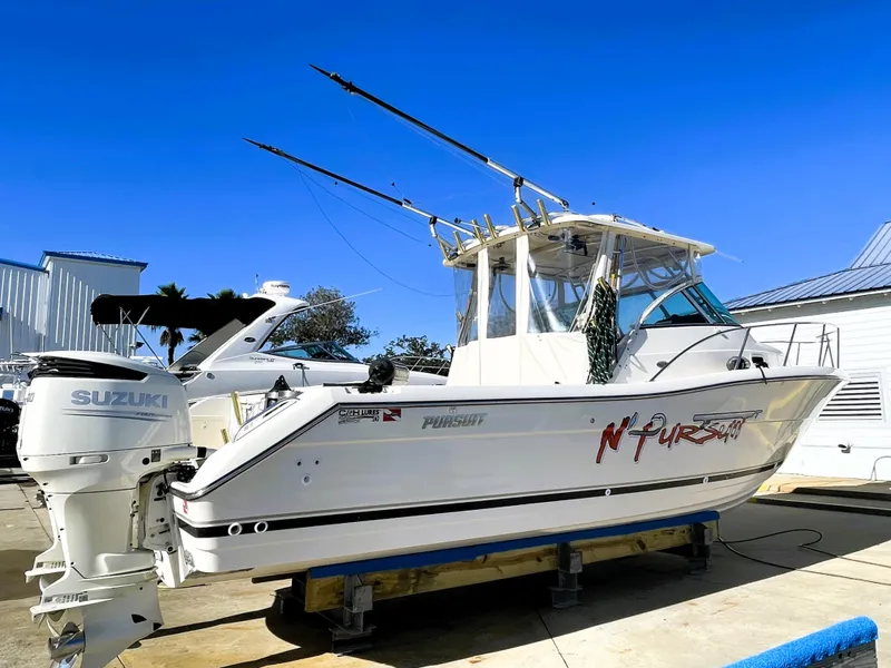 Slide: The Image of 2005 Pursuit 3070 Offshore boat with Suzuki outboard engines on a sunny day. - 2