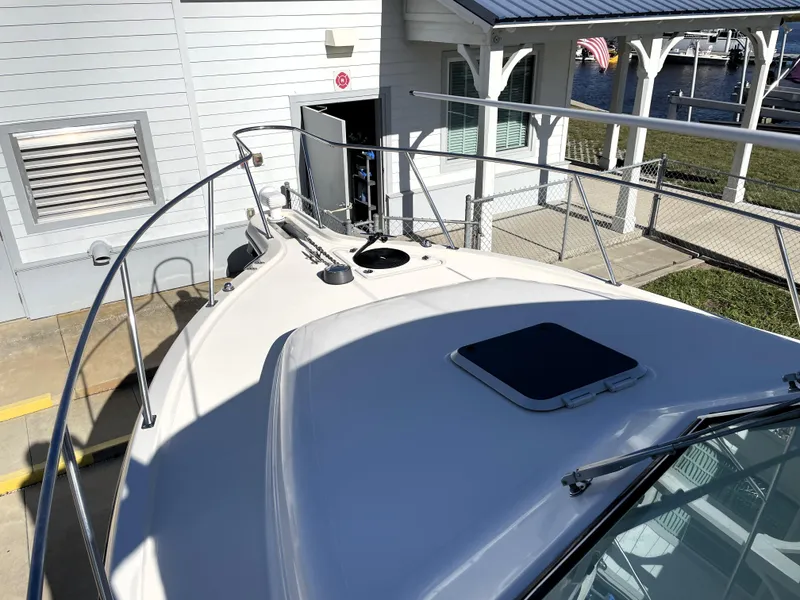 Slide: The Image of 2005 Pursuit 3070 Offshore boat docked near a marina building. - 26