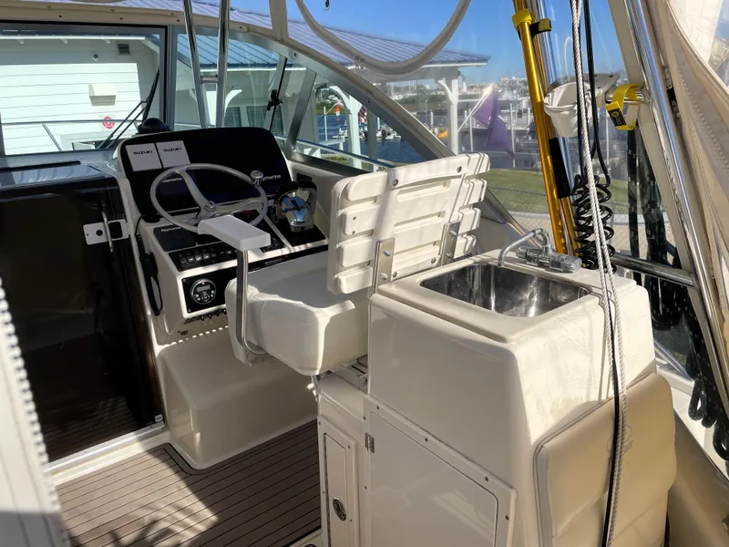 Slide: The Image of 2005 Pursuit 3070 Offshore boat cockpit with helm station and sink. - 33