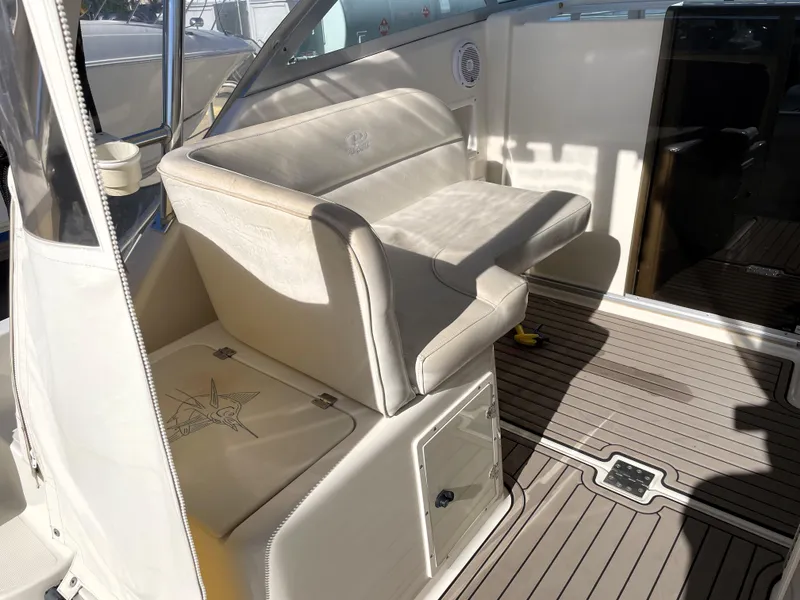 Slide: The Image of 2005 Pursuit 3070 Offshore boat interior with cushioned seating and storage. - 35