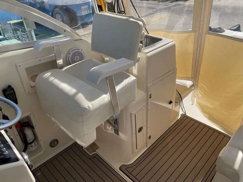Slide: The Image of Captain's chair on a 2005 Pursuit 3070 Offshore boat, featuring a clean, white interior. - 36