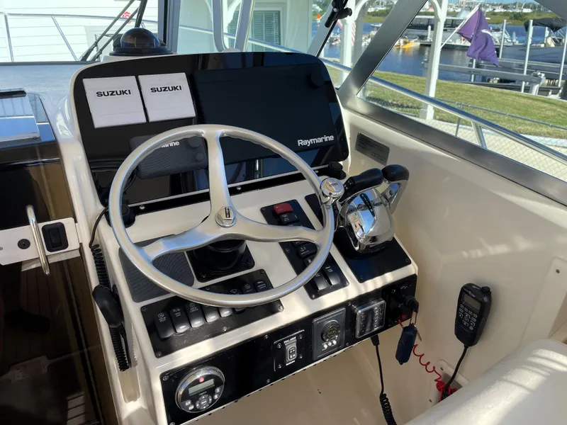 Slide: The Image of 2005 Pursuit 3070 Offshore boat helm with Raymarine electronics and Suzuki controls. - 41