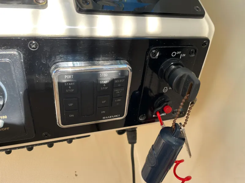 Slide: The Image of Control panel of a 2005 Pursuit 3070 Offshore boat with Suzuki engine start/stop buttons. - 45