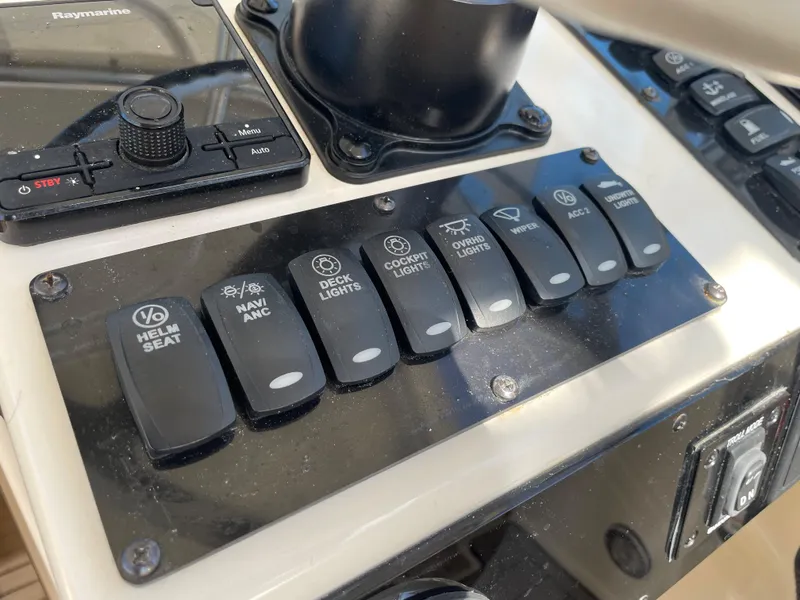 Slide: The Image of Control panel of a 2005 Pursuit 3070 Offshore boat with various switches. - 49