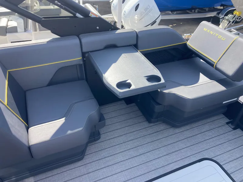 Slide: The Image of 2024 Manitou Explorer 24 Switchback 24 MAX Trifold Stealth boat interior with seating and table. - 15