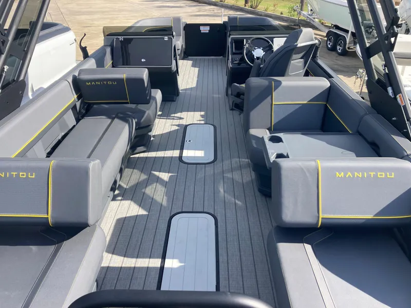 Slide: The Image of 2024 Manitou Explorer 24 Switchback 24 MAX Trifold Stealth interior with gray seating and yellow accents. - 19