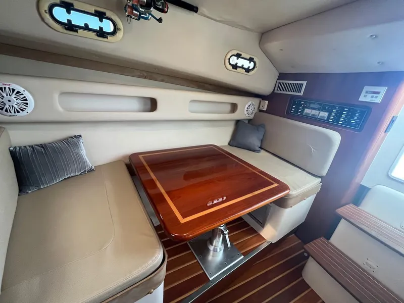 Slide: The Image of Interior cabin of a 2000 Pursuit 3000 Express boat with a wooden table and beige seating. - 13