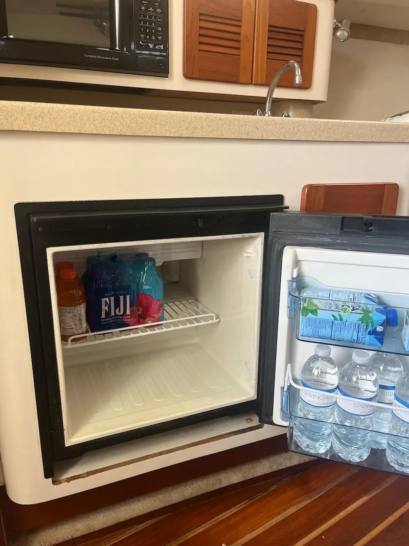 Slide: The Image of Mini fridge in 2000 Pursuit 3000 Express boat with bottled water and beverages. - 15