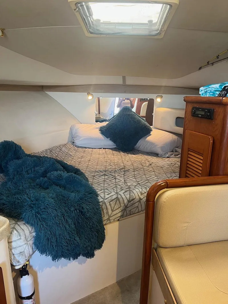 Slide: The Image of 2000 Pursuit 3000 Express cabin with cozy bed and blue blanket. - 16