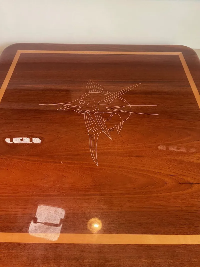 Slide: The Image of Polished wooden table with marlin engraving on 2000 Pursuit 3000 Express boat. - 18