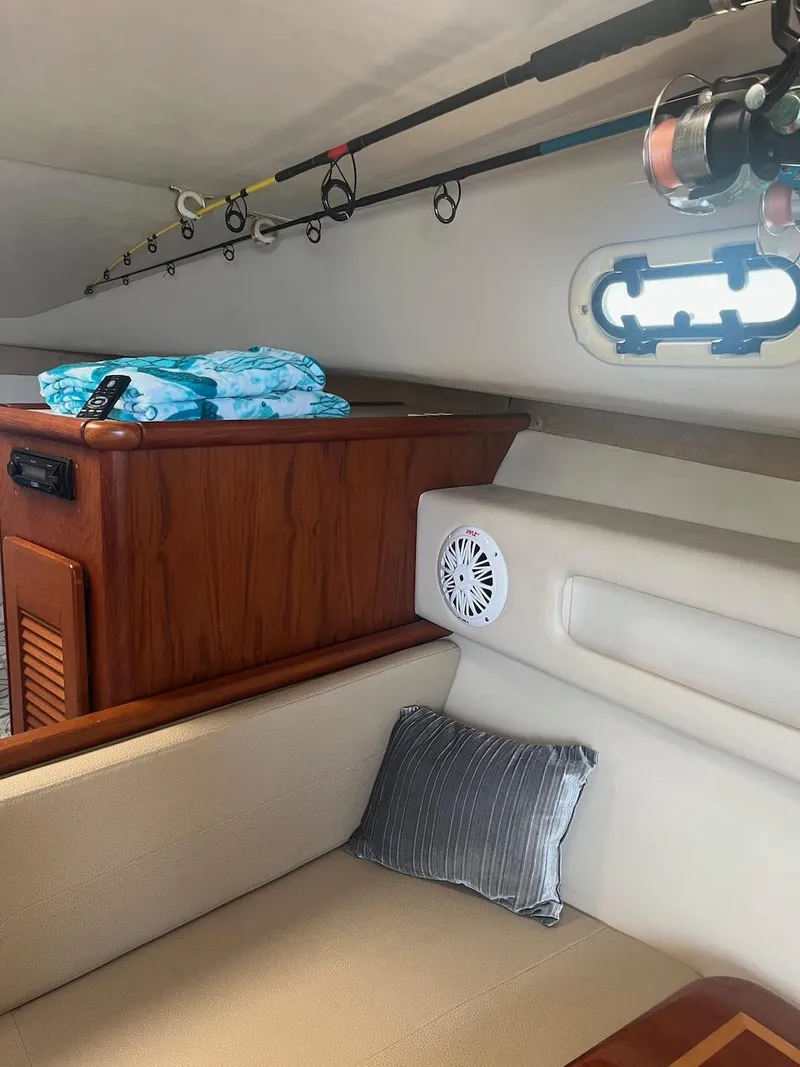 Slide: The Image of Interior of 2000 Pursuit 3000 Express boat with fishing rods and seating area. - 19