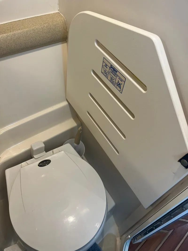 Slide: The Image of 2000 Pursuit 3000 Express boat bathroom with toilet and foldable seat. - 23