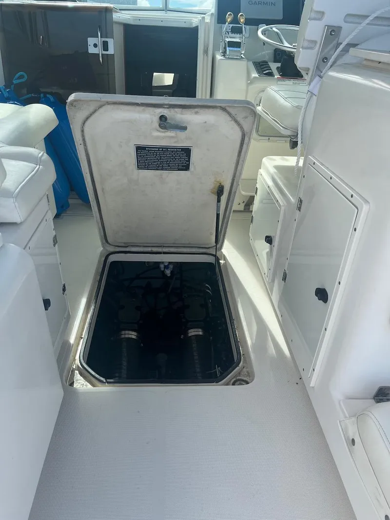 Slide: The Image of Open engine hatch on a 2000 Pursuit 3000 Express boat, revealing engine compartment. - 29