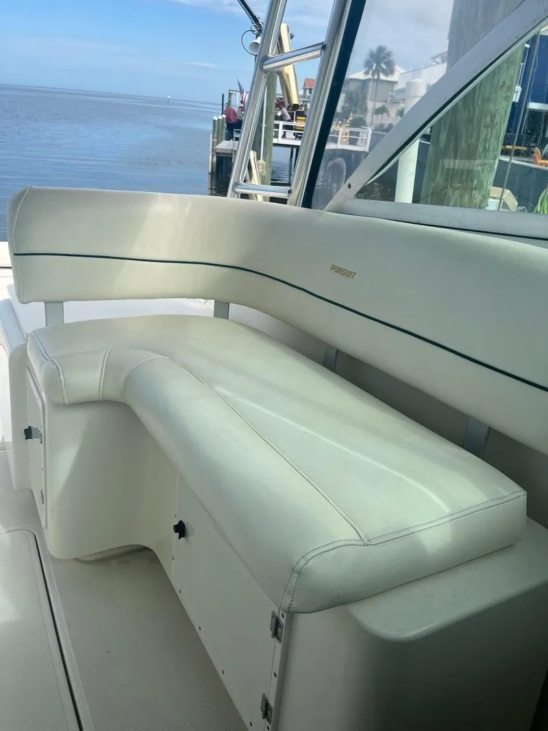 Slide: The Image of 2000 Pursuit 3000 Express boat interior with white cushioned seating. - 5