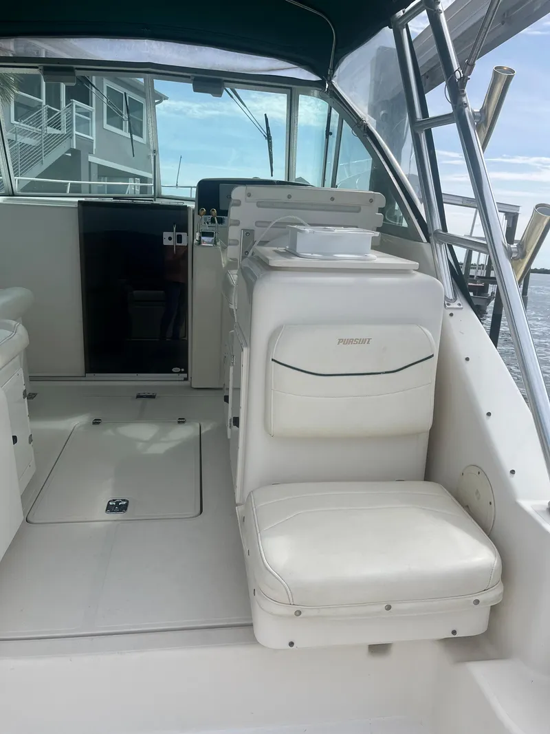 Slide: The Image of 2000 Pursuit 3000 Express boat interior with white seating and helm station. - 6