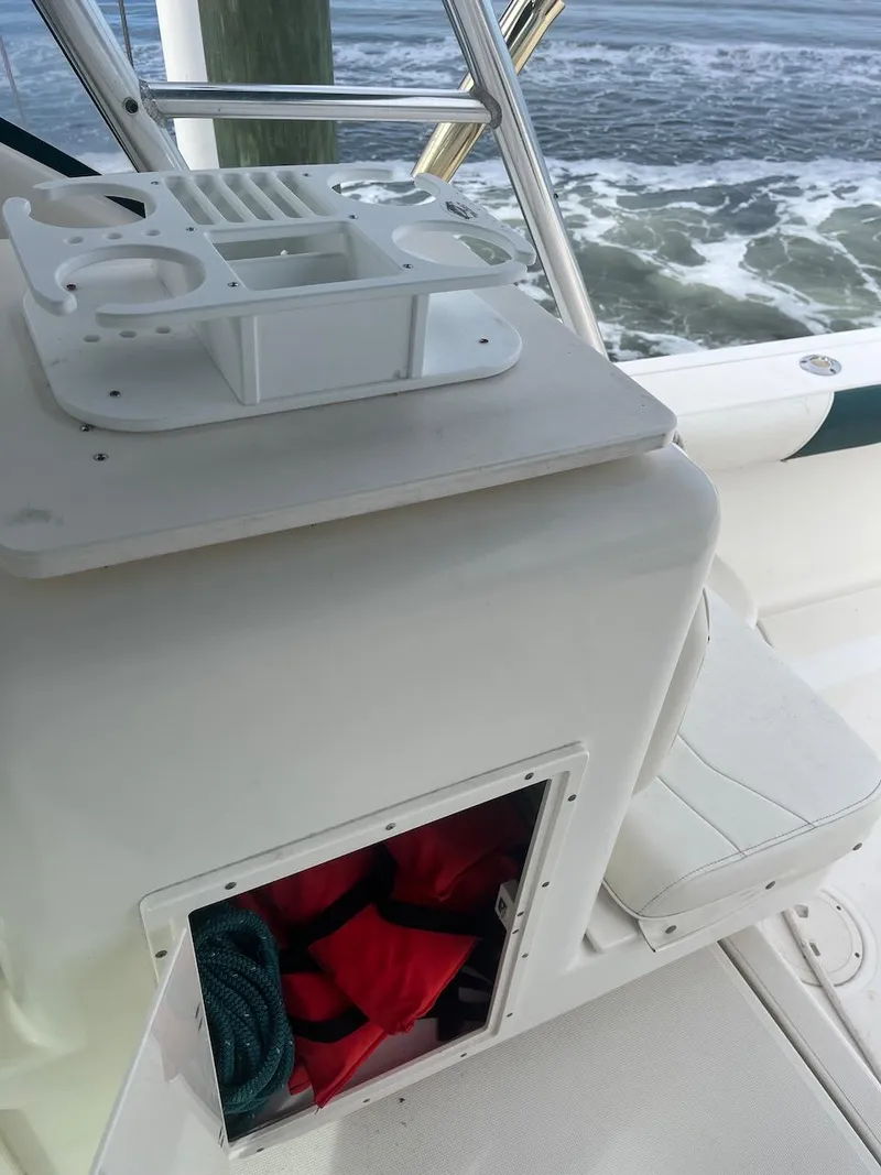 Slide: The Image of 2000 Pursuit 3000 Express boat interior with storage compartment and ocean view. - 7