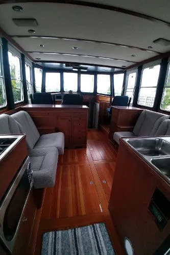 Slide: The Image of Interior of 2007 Custom Rockport Steel Trawler MY with wooden flooring and seating area. - 25