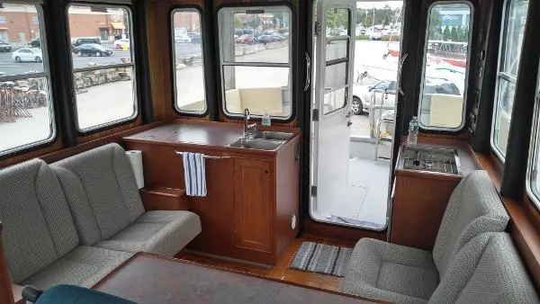 Slide: The Image of 2007 Custom Rockport Steel Trawler MY interior with seating, kitchenette, and large windows. - 33