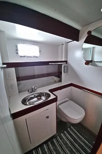 Slide: The Image of 2007 Custom Rockport Steel Trawler MY bathroom with sink, toilet, and mirror. - 48