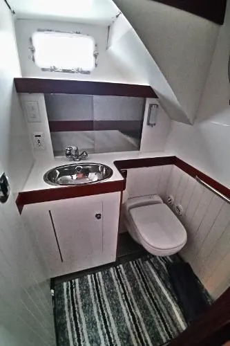 Slide: The Image of 2007 Custom Rockport Steel Trawler MY bathroom with sink, toilet, and window. - 49
