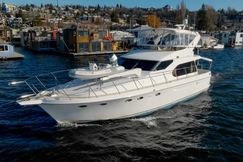 Slide: The Image of 2003 Ocean Alexander 48 Sedan yacht cruising near a coastal town. - 0