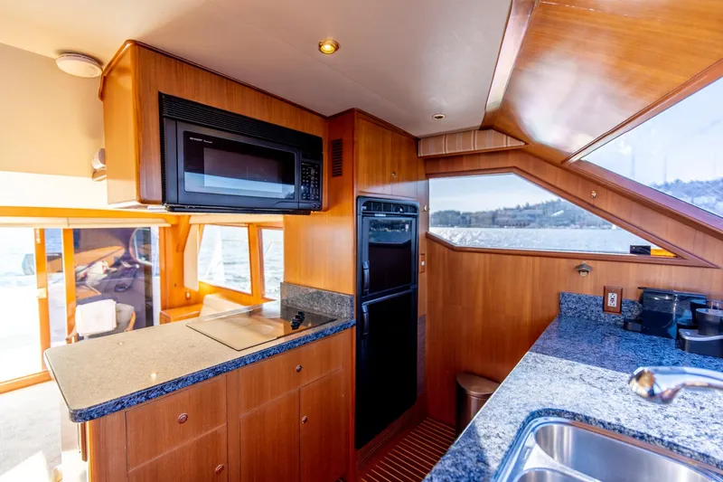 Slide: The Image of 2003 Ocean Alexander 48 Sedan yacht kitchen with granite countertops and modern appliances. - 14