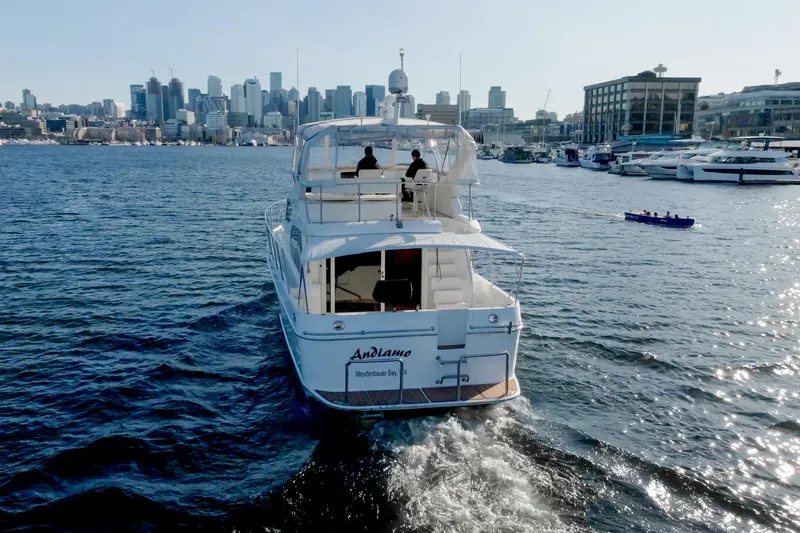 Slide: The Image of 2003 Ocean Alexander 48 Sedan cruising in a city harbor with skyline in the background. - 4