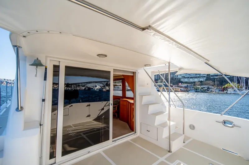 Slide: The Image of 2003 Ocean Alexander 48 Sedan yacht deck with sliding glass door and stairs. - 5