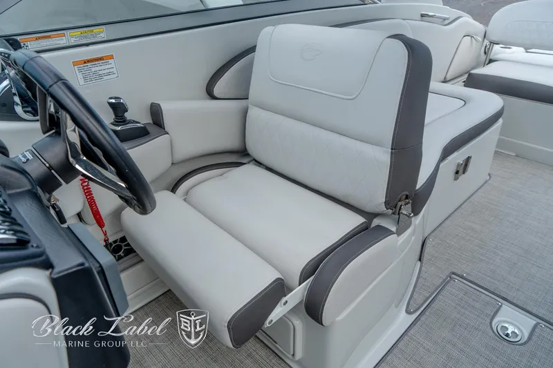 Slide: The Image of 2024 Crownline E305 XS boat interior with plush seating and steering wheel. - 15