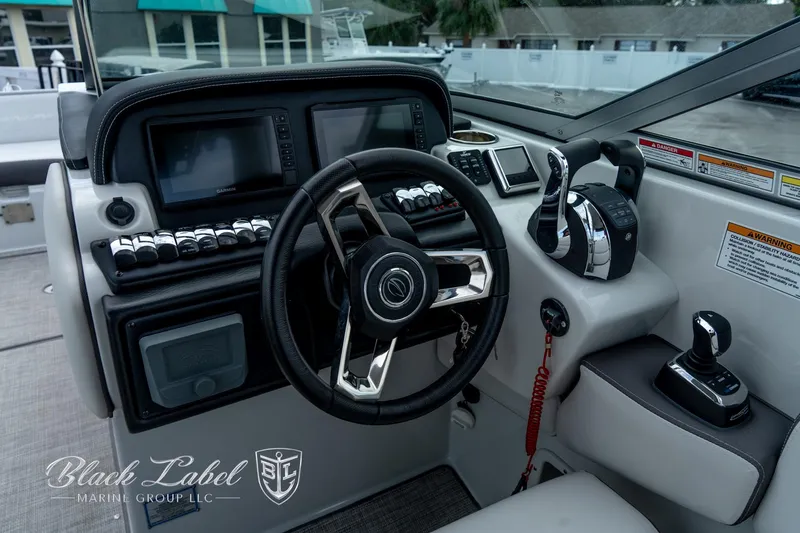 Slide: The Image of 2024 Crownline E305 XS boat dashboard with steering wheel and controls. - 16