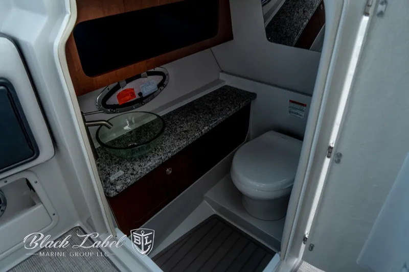 Slide: The Image of 2024 Crownline E305 XS boat interior bathroom with granite countertop and modern fixtures. - 18