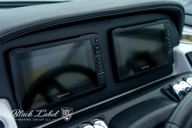 Slide: The Image of 2024 Crownline E305 XS dashboard with dual Garmin displays, Black Label Marine Group branding. - 24