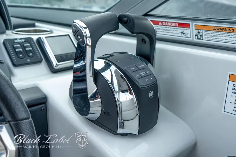 Slide: The Image of 2024 Crownline E305 XS boat throttle controls in cockpit, featuring sleek design and modern technology. - 27