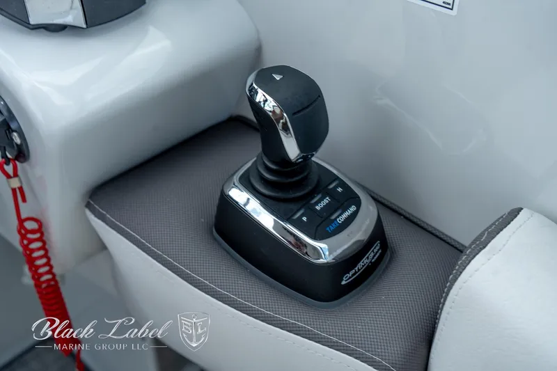 Slide: The Image of 2024 Crownline E305 XS boat joystick control on a sleek console. - 28