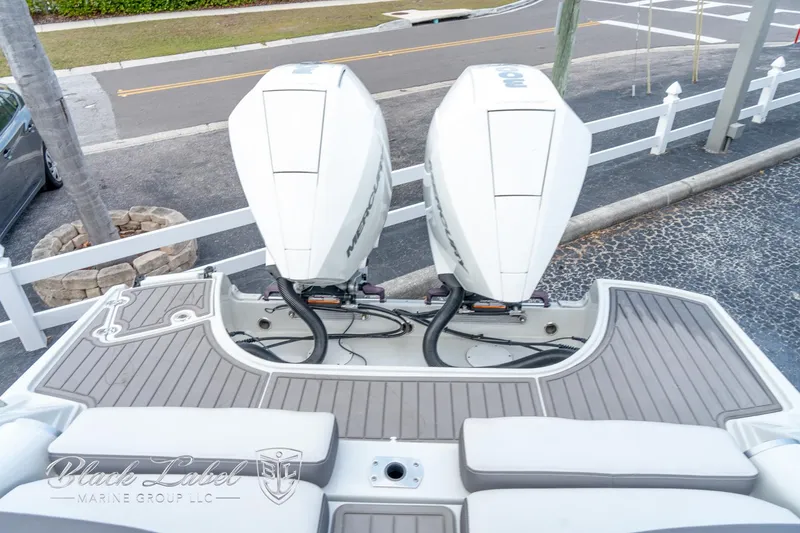 Slide: The Image of 2024 Crownline E305 XS boat with dual outboard engines, docked on a textured surface. - 33
