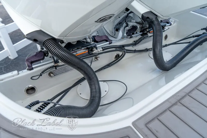 Slide: The Image of 2024 Crownline E305 XS boat engine compartment with visible hoses and wiring. - 35