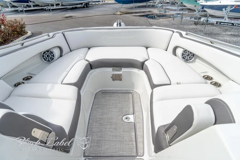 Slide: The Image of 2024 Crownline E305 XS boat interior with white and gray seating, cup holders, and speakers. - 7