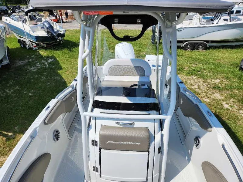 Slide: The Image of 2024 Finseeker 210 FinSeeker boat interior with seating and console, displayed outdoors. - 5
